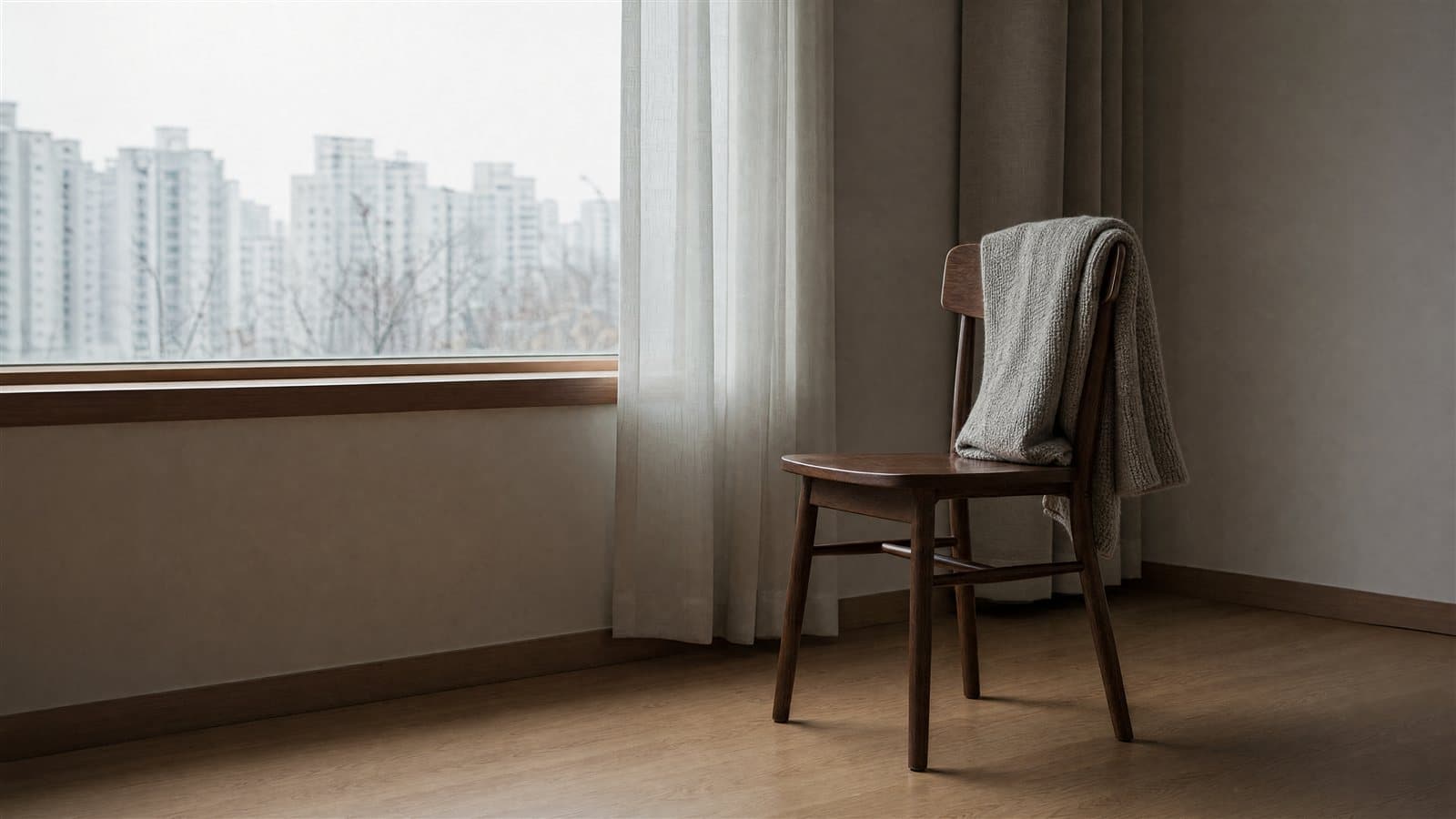 창가에 놓인 빈 의자 하나와 접힌 무릎담요 — 위자료는 겪은 고통의 크기를 그대로 환산하는 제도가 아니라 여러 사정을 종합해 정해지는 배상입니다